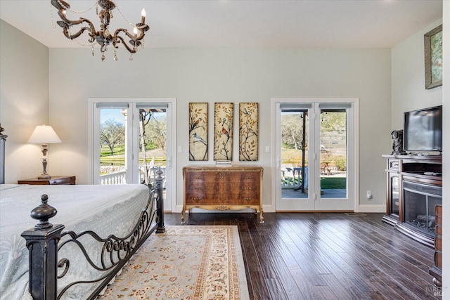 bedroom featuring dark hardwood / wood-style floors, a chandelier, and access to outside