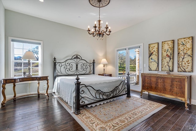 bedroom featuring dark hardwood / wood-style floors, access to outside, and a notable chandelier