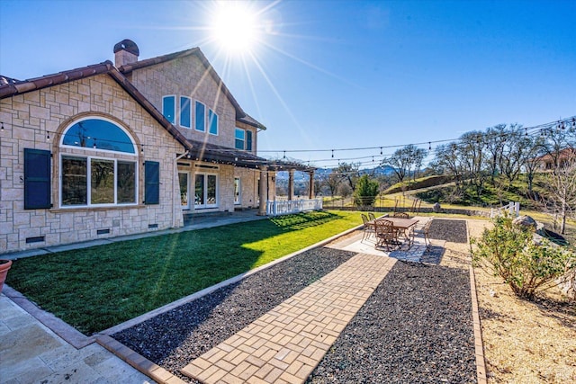 rear view of house featuring a patio and a lawn