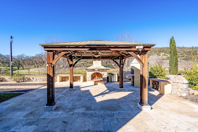 view of patio / terrace with a gazebo and an outdoor stone fireplace