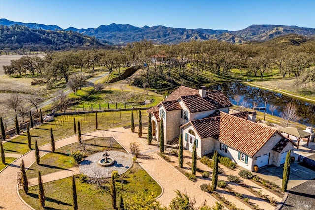 birds eye view of property with a water and mountain view