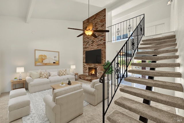 living room featuring ceiling fan, a towering ceiling, beam ceiling, and a fireplace