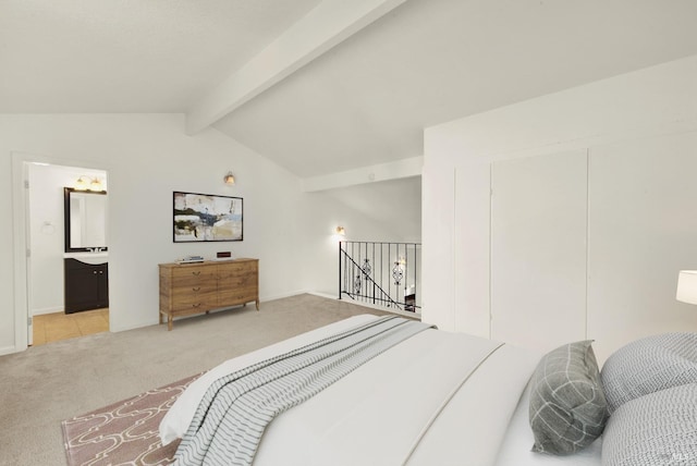 carpeted bedroom with vaulted ceiling with beams and ensuite bathroom