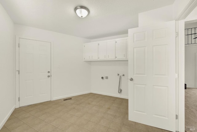 clothes washing area featuring cabinets, hookup for a washing machine, hookup for an electric dryer, and a textured ceiling