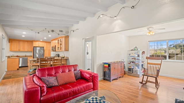 living room with vaulted ceiling with beams, sink, ceiling fan, and light wood-type flooring