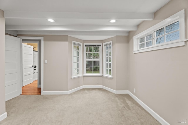 spare room with baseboards, beamed ceiling, recessed lighting, and light colored carpet