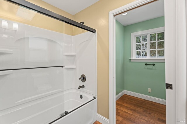 bathroom with combined bath / shower with glass door and hardwood / wood-style floors