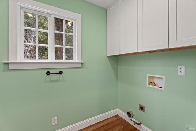 washroom with cabinets, wood-type flooring, washer hookup, hookup for an electric dryer, and hookup for a gas dryer