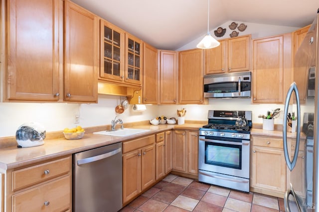 kitchen featuring lofted ceiling, sink, appliances with stainless steel finishes, hanging light fixtures, and light brown cabinetry