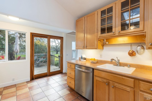 kitchen featuring light tile patterned flooring, stainless steel dishwasher, lofted ceiling, and sink