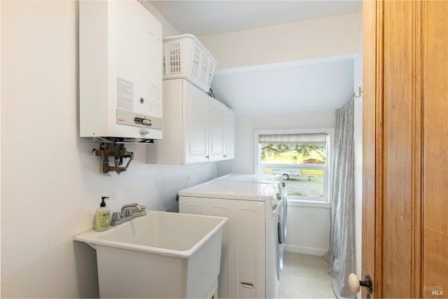 laundry room featuring sink, washer and clothes dryer, cabinets, and water heater