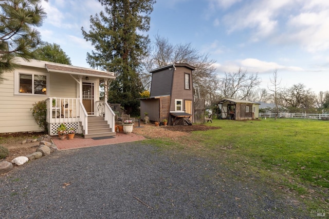 view of front of property with a storage unit and a front yard