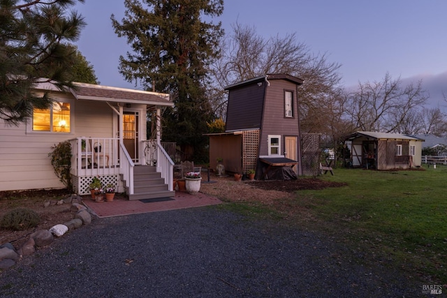 view of front of home with a yard and a storage unit