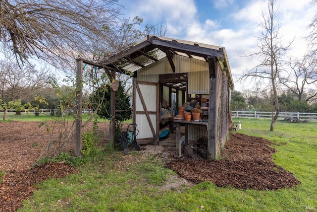 view of outdoor structure featuring a yard and a rural view