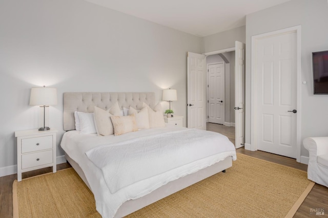 bedroom with dark hardwood / wood-style floors