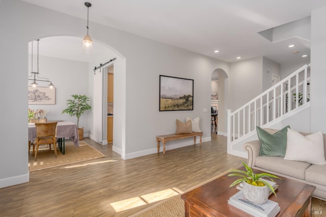 living room with a barn door and hardwood / wood-style floors