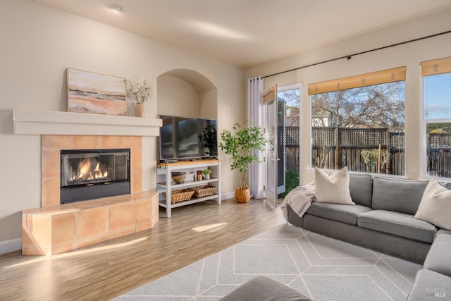 living room with hardwood / wood-style floors and a tile fireplace