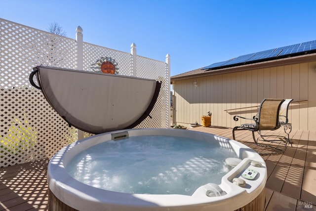 wooden deck with a covered hot tub