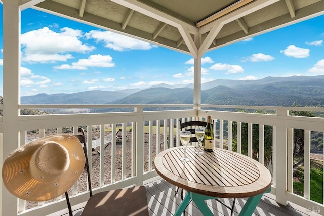 balcony featuring a sunroom and a water and mountain view