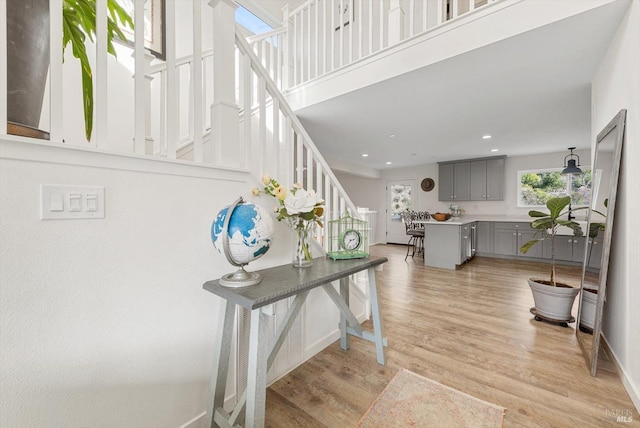 interior space featuring baseboards, light wood finished floors, stairway, and recessed lighting