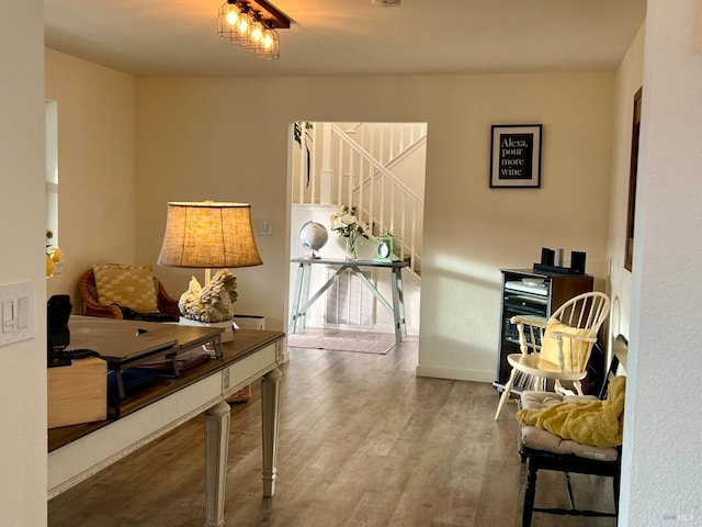 living area featuring stairs, baseboards, and wood finished floors