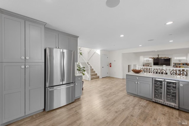 kitchen featuring light countertops, gray cabinetry, freestanding refrigerator, open floor plan, and beverage cooler