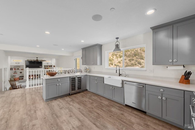 kitchen featuring beverage cooler, light countertops, gray cabinets, dishwasher, and decorative light fixtures