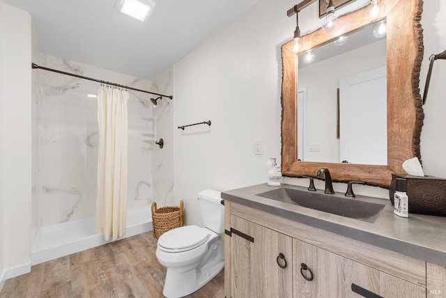 full bathroom with toilet, a shower stall, wood finished floors, and vanity