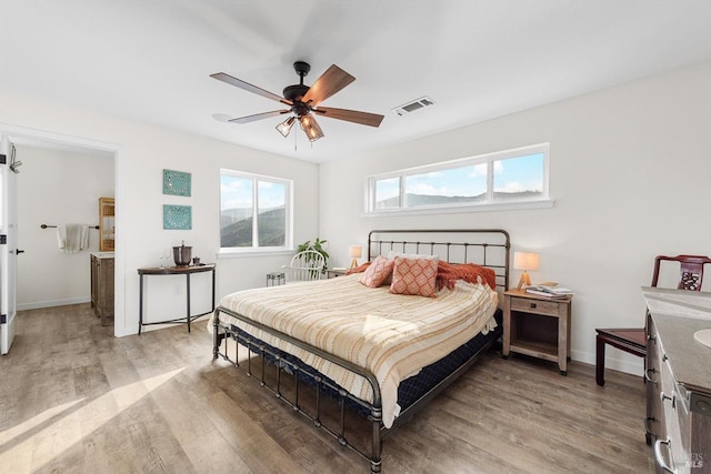 bedroom featuring light wood-style floors, visible vents, ceiling fan, and baseboards