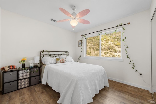 bedroom with visible vents, dark wood finished floors, baseboards, and ceiling fan