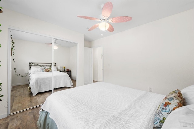 bedroom with ceiling fan, dark wood-type flooring, and a closet