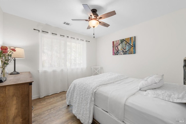 bedroom with a ceiling fan, visible vents, and light wood-style floors