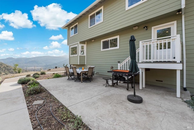 view of patio with outdoor dining area and a mountain view