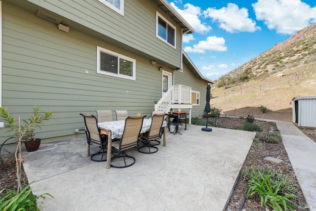 view of patio featuring outdoor dining space and fence