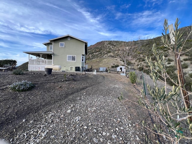 view of home's exterior with gravel driveway and a mountain view