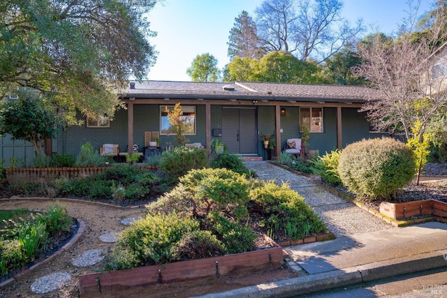 single story home featuring a porch and brick siding