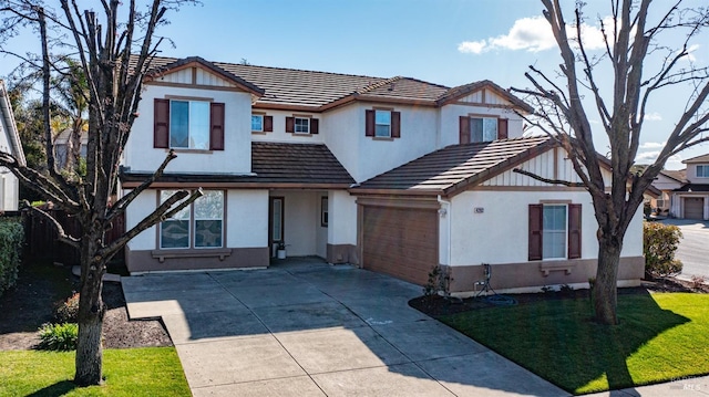 view of front of home featuring stucco siding, a front lawn, concrete driveway, and a tiled roof