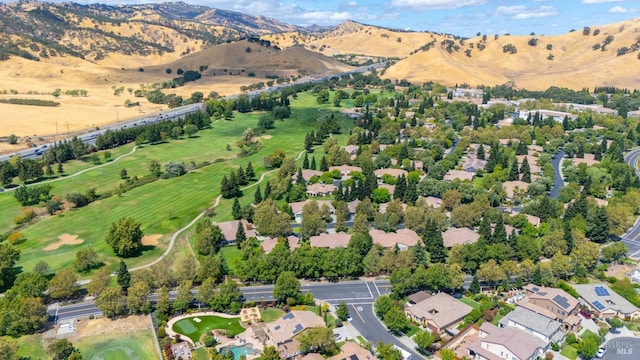 drone / aerial view with view of golf course and a mountain view