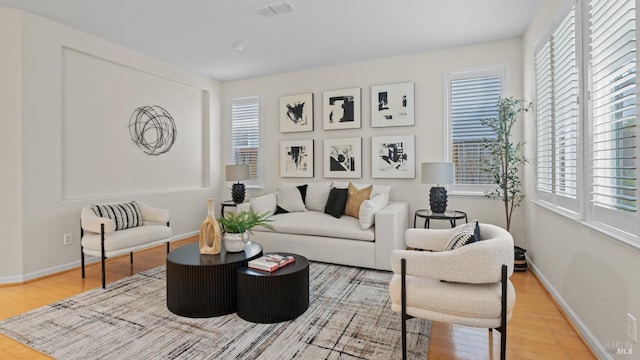living area featuring a wealth of natural light, wood finished floors, and visible vents
