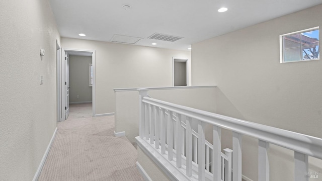 corridor with light carpet, baseboards, visible vents, recessed lighting, and an upstairs landing