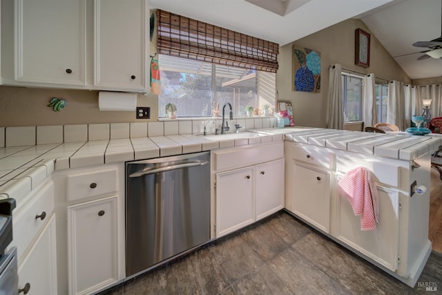 kitchen with ceiling fan, stainless steel dishwasher, tile counters, and white cabinets