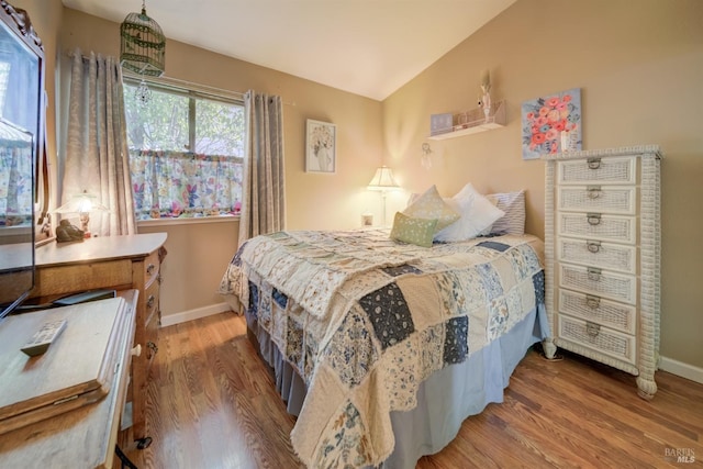 bedroom featuring hardwood / wood-style flooring and vaulted ceiling