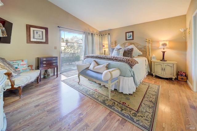 bedroom featuring lofted ceiling, access to exterior, and light hardwood / wood-style flooring