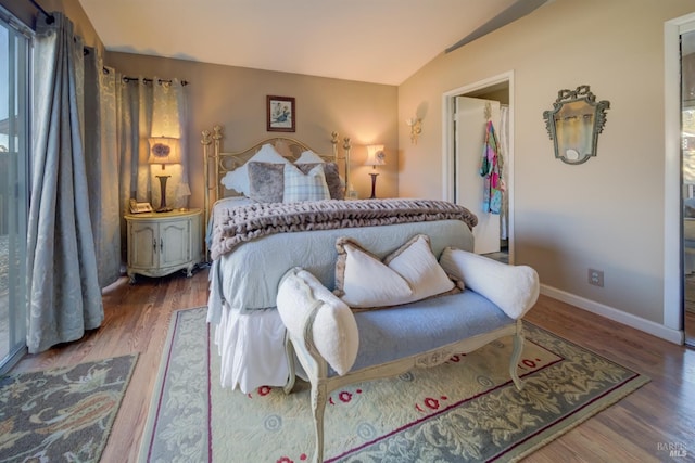 bedroom featuring hardwood / wood-style flooring and vaulted ceiling