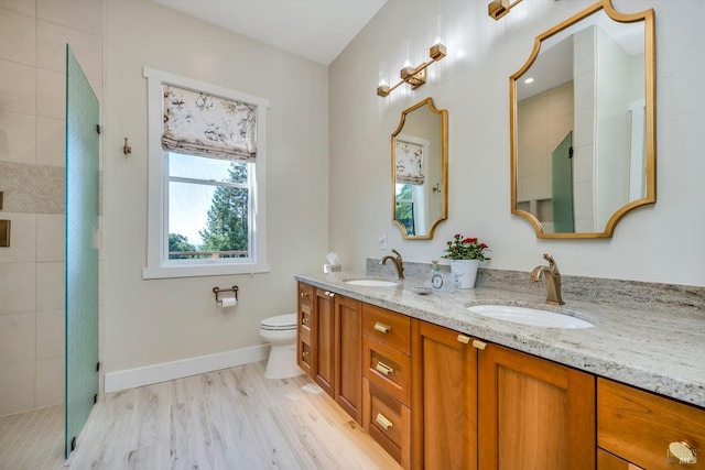 bathroom featuring hardwood / wood-style flooring, vanity, toilet, and a shower with shower door