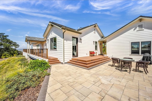 back of house featuring a deck and a patio