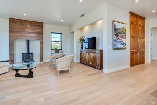 living room featuring light wood-type flooring and a wood stove