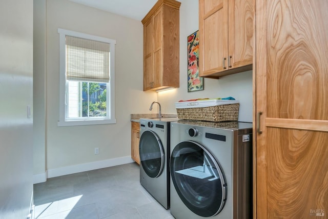 laundry room with cabinets, light tile patterned floors, and separate washer and dryer