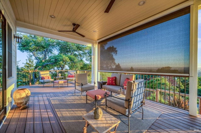 wooden terrace with an outdoor living space and ceiling fan