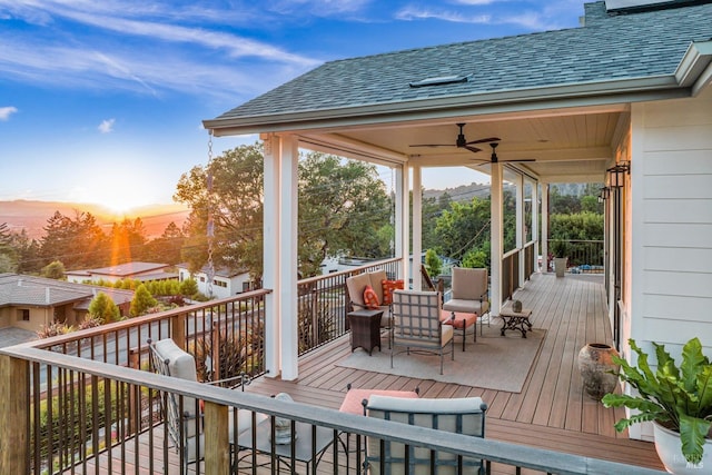 deck at dusk featuring an outdoor living space and ceiling fan